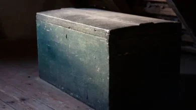 صندوق خشبي قديم مغلق في ضوء خافت يعكس الغموض