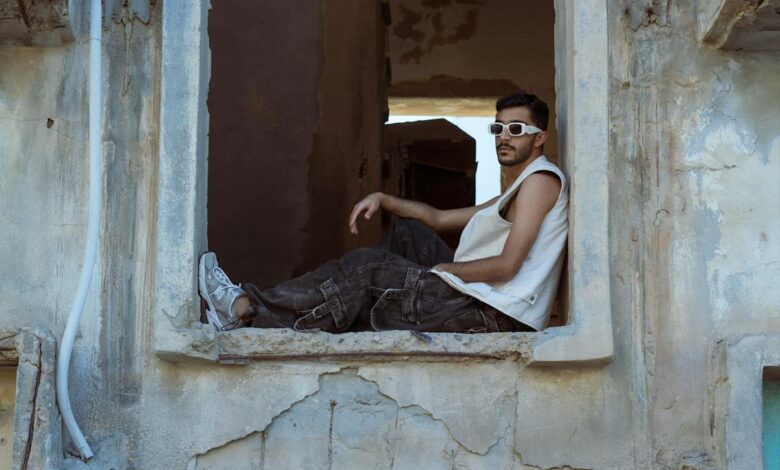 شاب ينظر من نافذة قديمة والدموع تملأ عينيه