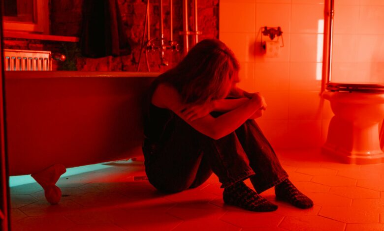 فتاة تجلس في الظلام تبكي بسبب خيانة أحد أفراد أسرتها