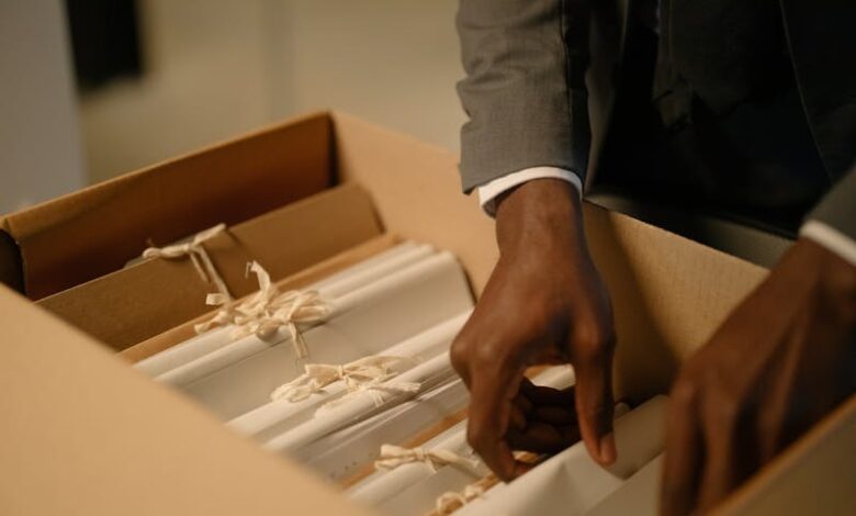 شاب يقف في أرشيف قديم يبحث في أسرار العائلة