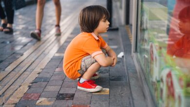 طفل يحدق في واجهة محل أحذية ليلة العيد بعينين مليئتين بالرجاء